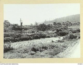 WAU - BULOLO ROAD, NEW GUINEA. 1944-04-26. VIEWING FROM THE WAU - BULOLO ROAD TOWARDS THE BULOLO NO. 1 POWER HOUSE WHICH WAS DESTROYED BY AUSTRALIAN COMMANDOS DURING THE JAPANESE ADVANCE ON WAU IN ..