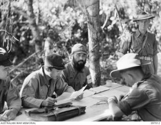 Lieutenant T. Katok (left) and Lieutenant Colonel (Lt Col) R. Minobe (right), Japanese Army medical officers, discussing the medical position of the Japanese soldiers at the Numa Numa Plantation ..