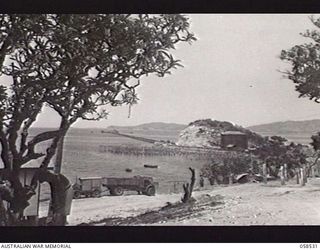 HANUABADA, NEW GUINEA. 1943-10-23. OIL PIPELINE AND STORAGE TANKS, SHOWING A TANKER UNLOADING AT THE END OF THE JETTY