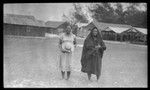 Two Cook Islands women, buildings in background