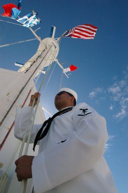 Onboard the US Navy (USN) Military Sealift Command (MSC), Hospital Ship, USNS MERCY (T-AH 19), USN Hospital Corpsman Third Class Misac Lopez lowers the ENSIGN as the ship passes the Arizona Memorial at Navy Base Pearl Harbor, Hawaii (HI). The USNS MERCY is starting a scheduled five-month deployment to deliver aid and humanitarian assistance to the Pacific Islands, and Southeast Asia.2006) Hospital Corpsman 3rd Class Misac Lopez lowers the ENSIGN as USNS Mercy (T-AH19) passes The Arizona Memorial in Pearl Harbor. Misac is an optometry technician on Mercy during its five month humanitarian assistance mission in the Pacific. During Mercy s deployment it will visit areas of South...