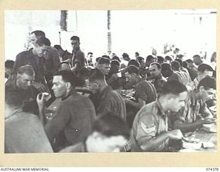 SIAR, NEW GUINEA. 1944-06-27. TROOPS ENJOYING THEIR LUNCH IN THE MESS HUT AT HEADQUARTERS, 15TH INFANTRY BRIGADE