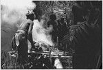 Pig festival, uprooting cordyline ritual, Tsembaga: in ancestral shrine, men heat stones for pandanus fruit dedication