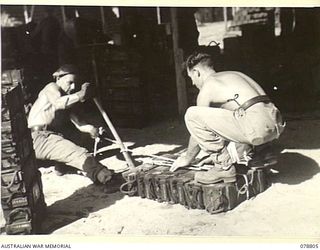 TOROKINA, BOUGAINVILLE ISLAND. 1945-01-29. WARRANT OFFICER II, R. THORN (1) AND PRIVATE R. NICHOLLS (2) OF THE SOLOMON'S DETACHMENT, 12TH AIR MAINTENANCE PLATOON (TS) 4TH BASE SUB AREA, BUNDLING ..