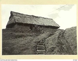 DUMPU, NEW GUINEA. 1944-04-19. VX102654 LIEUTENANT L.S. PROBY, MC, (1), WITH VX112180 CAPTAIN S.R. HEDLEY (INTELLIGENCE OFFICER) (2), MOVING DOWN THE HILLSIDE STEPS FROM THE OFFICERS' MESS, ..