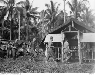 NORTH ALEXISHAFEN, NEW GUINEA. 1944-09-14. TROOPS OF THE 133RD BRIGADE ORDNANCE FIELD PARK ENTERING THEIR NEWLY COMPLETED BEER GARDEN AFTER RECEIVING THEIR BEER ISSUE. IDENTIFIED PERSONNEL ARE: ..