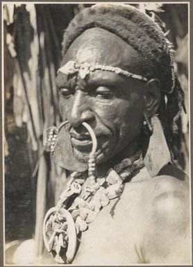 Wanigella [Wanigela] village [Close up view of a man's head wearing an elaborate necklace] Frank Hurley