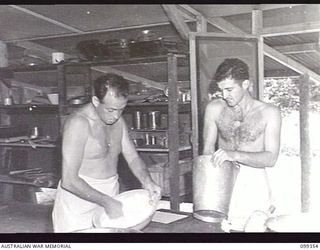 TOROKINA, BOUGAINVILLE, 1945-12-04. PRIVATE H. C. GANET (1) AND PRIVATE K. G. COSTELLOE (2) PREPARING A MIXTURE FOR THE MAKING OF A FRUIT CAKE AT THE COOKERY CLASS, TOROKINA REHABILITATION TRAINING ..