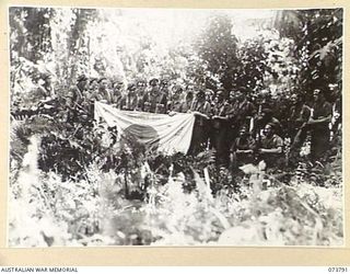 KARKAR ISLAND, NEW GUINEA. 1944-06-03. MEMBERS OF NO 12 PLATOON, B COMPANY, 37/52ND INFANTRY BATTALION DISPLAYING A JAPANESE FLAG WHICH WAS FOUND ON THE ISLAND. VX109408 PRIVATE J J MCDONNELL (1); ..