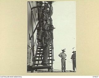 SIAR, NEW GUINEA. 1944-07-25. TROOPS OF THE 61ST INFANTRY BATTALION, MOVING DOWN THE GANGWAY OF THE TRANSPORT SHIP (TS) "KATOOMBA" INTO LANDING BARGES ON THE LAST LEG OF THEIR JOURNEY FROM MADANG. ..