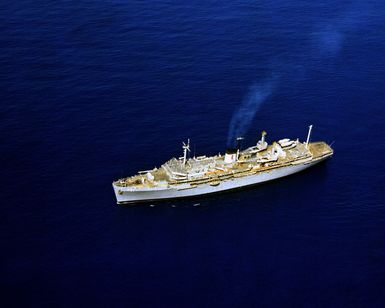 A port view of the submarine tender USS HUNLEY (AS-31) underway