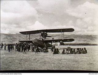 Garoka, New Guinea, 1945. Nicknamed The Duck, a Supermarine Walrus amphibian aircraft probably of No. 8 Communications Unit RAAF stands on the Garoka airstrip. A large crowd of native Papuans is ..