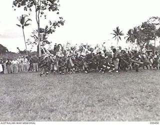 LAE, NEW GUINEA, 1945-12-25. A DANCE IN PROGRESS AT THE NATIVE SING-SING HELD AT THE MALAHANG NATIVE LABOUR COMPOUND TO CELEBRATE CHRISTMAS. MANY ALLIED AND AUSTRALIAN NEW GUINEA ADMINISTRATIVE ..
