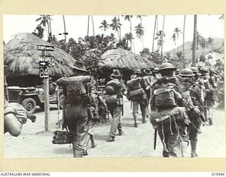 1943-10-08. NEW GUINEA. MARKHAM VALLEY. KAIAPIT. AUSTRALIAN TROOPS LEAVING KAIAPIT VILLAGE PASS A SIGN POST SHOWING THE WAY TO MARAWASA. (NEGATIVE BY G. SHORT)