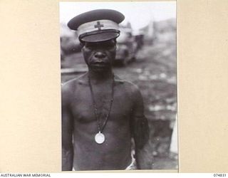 LAE, NEW GUINEA. 1944-07-22. GARTER, A NATIVE "DOCTOR" PROUDLY DISPLAYING A MEDAL WHICH HE HAS JUST BEEN AWARDED BY THE GENERAL OFFICER COMMANDING, AUSTRALIAN NEW GUINEA ADMINISTRATIVE UNIT FOR HIS ..