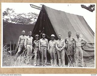 DREGER HARBOUR, NEW GUINEA. 1943-12-05. COMMANDING OFFICER AND OFFICERS OF TE 348TH UNITED STATES FIGHTER GROUP PHOTOGRAPHED IN FRONT OF THEIR GROUP HEADQUARTERS