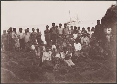 Local men, women and children on the landing rock at Merelava and the Southern Cross in background, Banks Islands, 1906 / J.W. Beattie