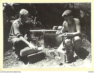 BOUGAINVILLE ISLAND. 1945-02-12. NX85014 PRIVATE T.C. JENSEN (1) AND QX37946 SERGEANT F.E. KAY (2), "C" COMPANY 9TH INFANTRY BATTALION, PREPARING BREAD AND BUTTER FOR MEMBERS OF THEIR COMPANY AT ..