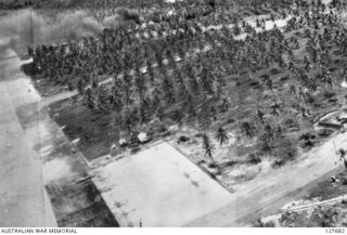 TOBERA, NEW BRITAIN. ? 1944-03. LOOKING BACK FROM A MITCHELL B25 BOMBER AIRCRAFT OF FIFTH AIR FORCE, UNITED STATES ARMY AIR FORCE, ON AIRSTRIP AND PLANTATION AFTER GAINING ALTITUDE. AIRCRAFT ARE ..