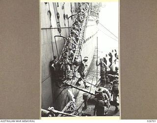 PORT MORESBY, PAPUA. 1942-09. TROOPS OF THE 25TH AUSTRALIAN INFANTRY BRIGADE DISEMBARKING FROM A TROOPSHIP TO A NAVAL CORVETTE FOR FERRYING TO THE WHARF