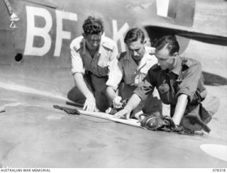 Informal portrait of NX107759 Captain John O Excell of Sydney, NSW, Australian Army  Air Liaison Officer (2) briefing 442350 Pilot Officer H T (Tiny) Kidman (1) and 400750 Flight Lieutenant Ian C ..