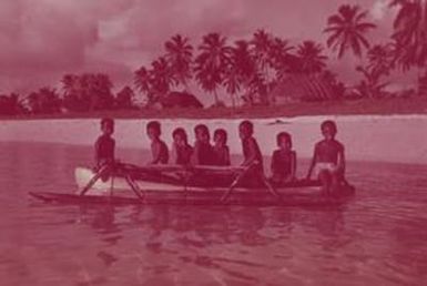 [Landscape view of boys sitting in a canoe near Fiji Island coastline]