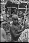 Mortuary ceremony, Omarakana: mourning girl, her face and body blackened with ash and her head shaved, carries infant