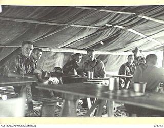 MILILAT, NEW GUINEA. 1944. TROOPS RELAXING IN THE RECREATION HUT WHICH IS JOINTLY RUN BY THE SALVATION ARMY AND THE AUSTRALIAN COMFORTS FUND SET AMONG THE COCONUT PALMS AT HEADQUARTERS, 5TH ..