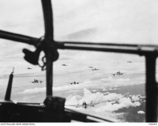 Airborne En Route to Lindenhafen, New Britain. 1944-01-17. View through the nose of a Beaufort Bomber aircraft of No. 100 Squadron RAAF, showing other Beaufort aircraft of Nos. 6, 8 and 100 ..