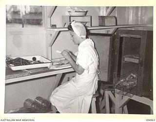 LAE AREA, NEW GUINEA. 1945-08-13. SISTER N.L. MORRISSON, 2/7 GENERAL HOSPITAL PREPARING PENICILLIN