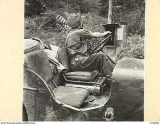 WAU - LAE ROAD, NEW GUINEA, 1944-02-26. WX8288 LANCE-CORPORAL C.R. FINCH (1), A DESPATCH RIDER FROM THE 1ST MECHANICAL EQUIPMENT PLATOON, 2/1ST RAILWAY CONSTRUCTION COMPANY, (MECHANICAL EQUIPMENT), ..