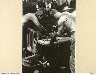 DALLMAN RIVER, NEW GUINEA, 1944-02-23. VX14568 CRAFTSMAN L.G. AGNEW (1), REPAIRING A JEEP ENGINE WITH VX140264 CRAFTSMAN O.J. PRICE (2). BOTH ARE MEMBERS OF THE 231ST LIGHT AID DETACHMENT ATTACHED ..