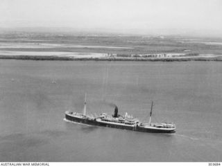 1940-16-12. AERIAL PORT QUARTER VIEW OF THE PASSENGER CARGO VESSEL NELLORE WHICH PICKED UP 496 SURVIVORS FROM VESSELS SUNK BY THE GERMAN AUXILIARY CRUISERS KOMET AND ORION FROM EMIRAU ISLAND, ..