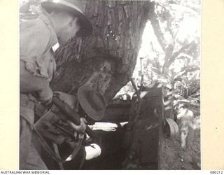 AWAR POINT, NEW GUINEA. 1944-07-09. MEMBERS OF NO.14 PLATOON, C COMPANY, 30TH INFANTRY BATTALION CHECK OUT A JAPANESE FOXHOLE