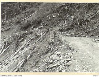 WAU - LAE ROAD, NEW GUINEA, 1944-02-27. THE ROAD BLOCKED BY A SLIDE FOURTY EIGHT AND A HALF MILES FROM WAU. THE SLIDE FOLLOWED THE PREVIOUS NIGHT'S RAIN, AND THE ROAD REMAINED BLOCKED UNTIL CLEARED ..