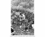 Richard Billings prepares plastic tubing for a study relating to ground water and plant growth, Enewetak Atoll, summer 1964