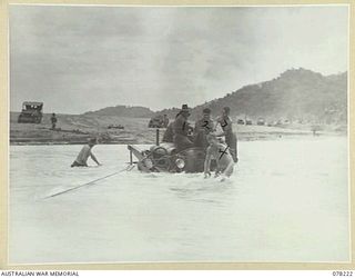 DANMAP RIVER, NEW GUINEA. 1945-01-06. TROOPS OF THE PIONEER PLATOON, 2/2ND FIELD COMPANY, SALVAGING ONE OF THE UNIT BULLDOZERS WHICH WAS SWEPT AWAY DURING THE HEAVY FLOODING OF THE RIVER ON THE ..