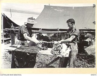 WEWAK POINT, NEW GUINEA. 1945-08-29. SIGNALMAN R.M. ELLIOTT (1) AND PRIVATE C.E. HADEN (2), MEMBERS OF 2/8 INFANTRY BATTALION, WASHING CLOTHES