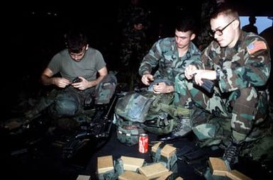 Marines on the hangar deck of the amphibious assault ship USS SAIPAN (LHA-2) fill their magazines with ammunition before boarding helicopters for transportation to Monrovia, Liberia, to evacuate dependents and non-essential U.S. Embassy staff from the midst of the fighting between Liberian government forces and rebel factions