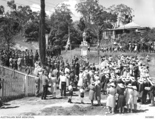 HERBERTON, QLD. 1944-04-25. THE ANZAC DAY SERVICE IN PROGRESS AT THE WAR MEMORIAL SHOWING TROOPS OF HEADQUARTERS, 6TH DIVISION ON THE LEFT AND PUPILS OF ST. MARY'S SCHOOL ON THE RIGHT