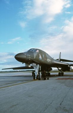 Flight line personnel stand beneath a B-1B aircraft parked on the flight line during Exercise DISTANT MARINER