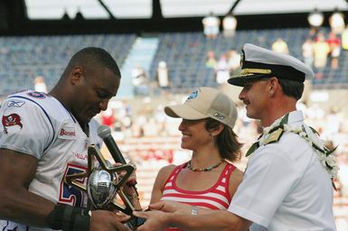 US Navy (USN) Rear Admiral (RDML) Michael C. Vitale (right), Commander, Navy Region Hawaii; and Commander, Naval Surface Group, Middle Pacific; presents the 2006 Pro Bowl Most Valuable Player (MVP) Award to Derrick Brooks )left), linebacker with the Tampa Bay Buccaneers, who is playing in his eighth National Football League (NFL) Pro Bowl