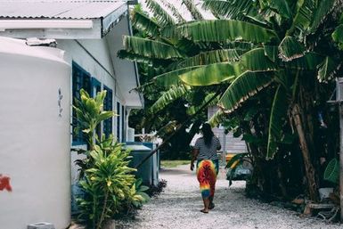 Woman in sarong walking away, Fakaofo, Tokelau