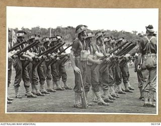 DONADABU, PAPUA, NEW GUINEA. 1944-01-01. A PLATOON FROM THE 57/60TH INFANTRY BATTALION AT "EXAMINE ARMS" POSITION BEING EXAMINED BY JUDGES DURING THE 15TH AUSTRALIAN INFANTRY BRIGADE GYMKHANA