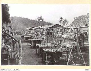 PIEDU ISLAND, SOLOMON ISLANDS. 1945-11-13. MESS TINS ON THEIR RACKS OUTSIDE THE CAMP HOSPITAL IN JAPANESE AREA 12. JAPANESE CONCENTRATED ON THE ISLAND ARE UNDER THE CONTROL OF 7 INFANTRY BATTALION