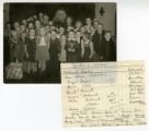 About 30 children standing with Santa Claus at Holy Cross Church, Dundas, Minnesota