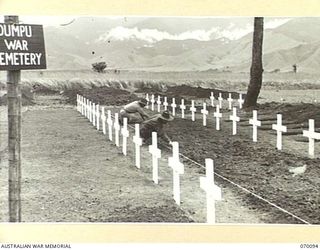 DUMPU, NEW GUINEA. 1944-01-25. NEAT WHITE CROSSES MARK GRAVES OF THE MEN WHO FELL IN THE MARKHAM AND RAMU VALLEY CAMPAIGNS. IT IS INTENDED THAT WHEN COMPLETED THE CEMETERY WILL BE THE BURIAL PLACE ..