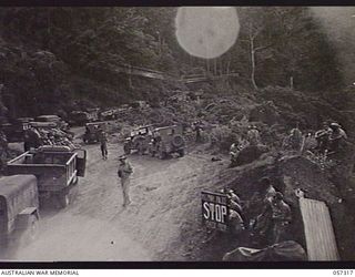 ROUNA, NEW GUINEA. 1943-09-24. VEHICLES HELD UP AT ROUNA TRAFFIC CONTROL POST NO. 2 BECAUSE OF BLASTING FURTHER ALONG THE ROAD