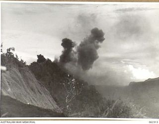 SHAGGY RIDGE, NEW GUINEA. 1943-12-27. 500 POUNDER BOMBS DROPPED FROM UNITED STATES ARMY FIGHTER AIRCRAFT EXPLODING ON JAPANESE POSITIONS ON THE "PIMPLE" DURING THE 2/16TH AUSTRALIAN INFANTRY ..