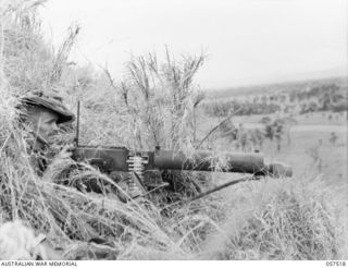 KAIAPIT, NEW GUINEA. 1943-09-23. SX9378 PRIVATE W. L. HICKS, GUNNER OF THE 2/27TH AUSTRALIAN INFANTRY BATTALION, BEHIND HIS VICKERS GUN OVERLOOKING THE MARKHAM VALLEY